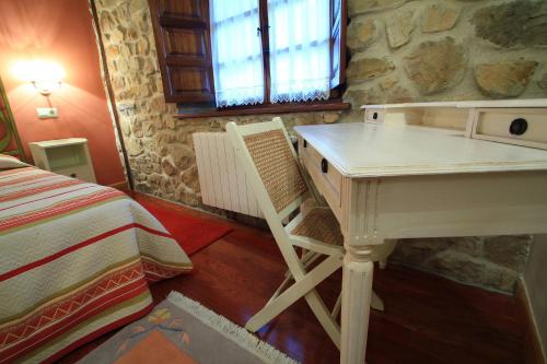 a bedroom with a white desk and a bed at Apartamentos Rurales Los Brezos* in Cotillo