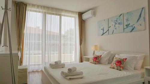 Un dormitorio con una cama con toallas. en Бяла Виста Клиф - Byala Vista Cliff, en Byala