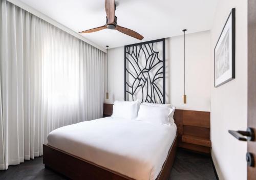 a bedroom with a bed and a ceiling fan at מלון רמב"ן ירושלים - קבוצת מחניודה in Jerusalem