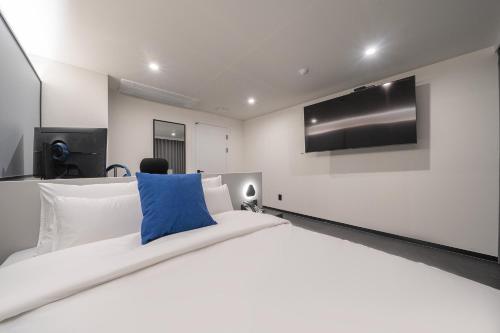 a bedroom with a large bed with a tv on the wall at Hotel Lavanda in Incheon