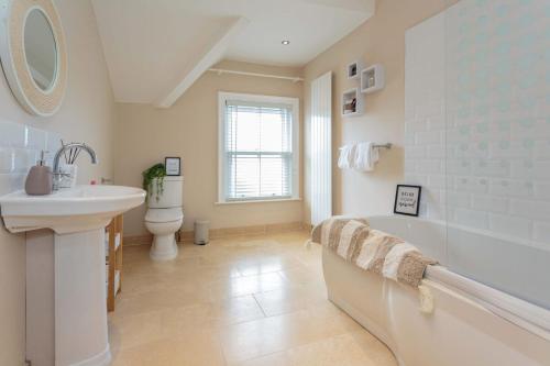 Un baño con lavabo, bañera e inodoro. en Orchard Lodge, en Lytham St Annes