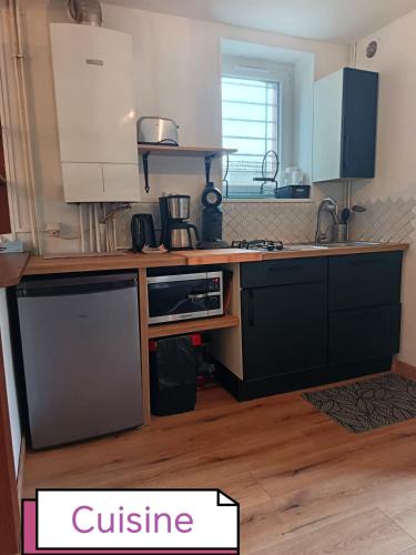 une cuisine avec un comptoir avec un micro-ondes dans l'établissement Maison Gambetta, à Ouistreham