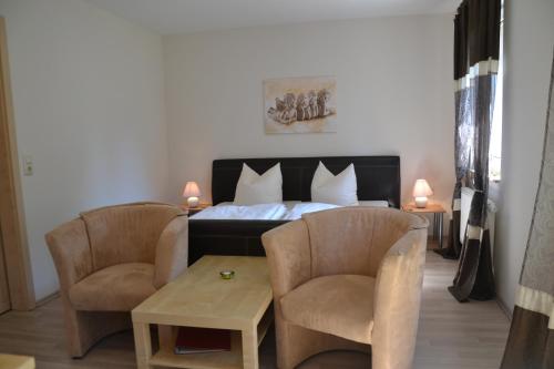 1 dormitorio con 1 cama con 2 sillas y 1 mesa en Töpferpark en Olbersdorf