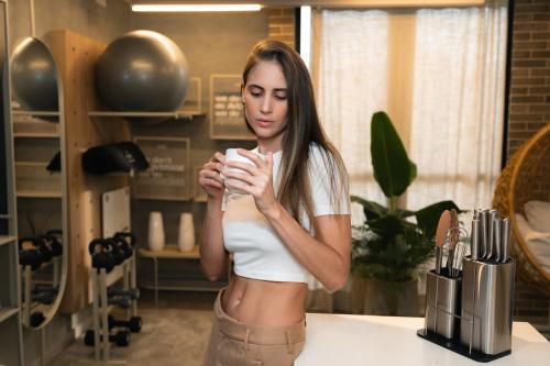 a woman standing in a kitchen holding a cup at Indie Universe Creative Hotel in Medellín