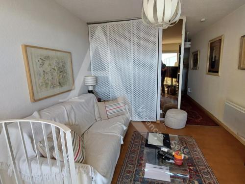 un salon avec un canapé blanc et une table dans l'établissement Duplex avec double terrasse 1ere ligne de mer, wifi et climatisation, à Sète