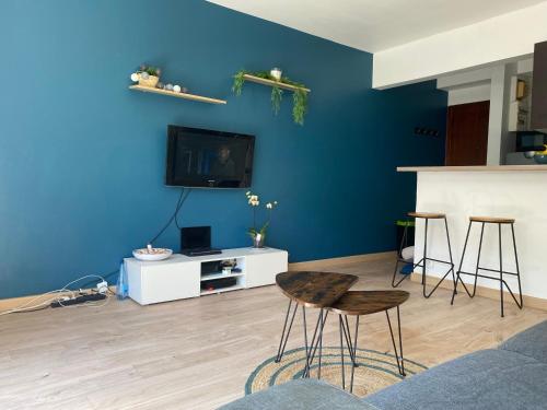 - un salon avec un mur bleu et deux tabourets de bar dans l'établissement Studio avec jardin, à Antibes