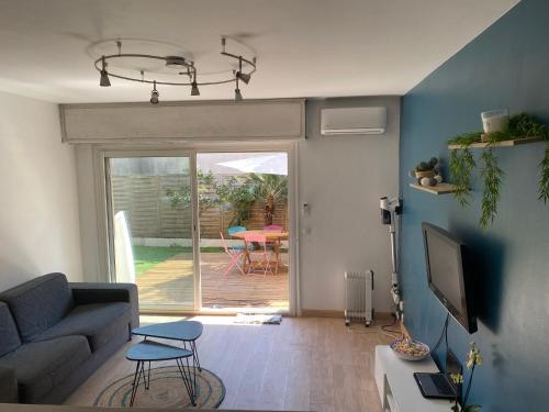 un salon avec un canapé et une télévision dans l'établissement Studio avec jardin, à Antibes