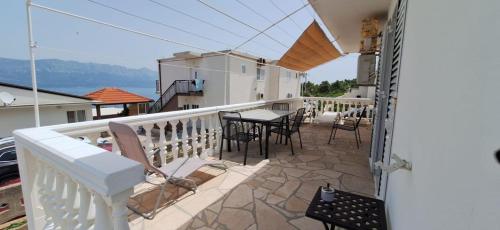 a balcony with a table and chairs on a house at House Karmela in Sućuraj