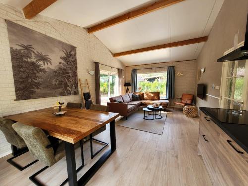 a living room with a table and a couch at Secret Wellness Heidezicht in Holten