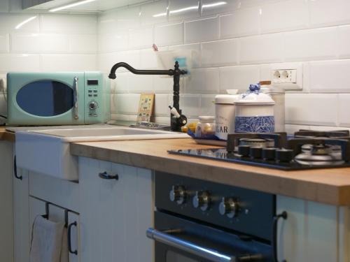 a kitchen counter with a sink and a microwave at Quiet groundfloor garden apartment close to Milan - SMART WORKING, RELAX, BARBECUE, NETFLIX in Trezzano sul Naviglio