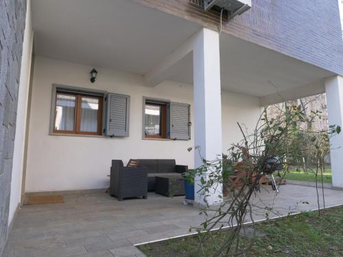 a white house with a couch and windows at Quiet groundfloor garden apartment close to Milan - SMART WORKING, RELAX, BARBECUE, NETFLIX in Trezzano sul Naviglio