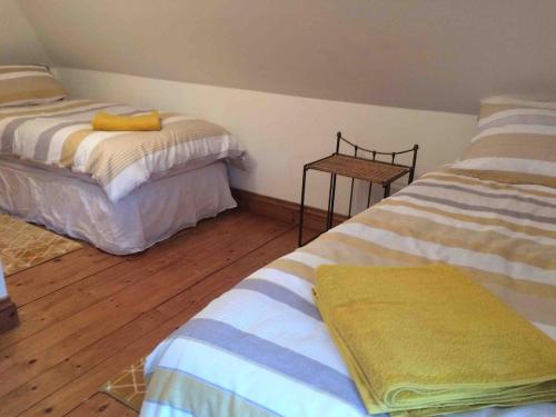 a bedroom with two beds and a wooden floor at Family seaside home, easy access to Edinburgh in Kinghorn