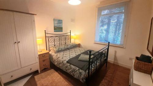 a bedroom with a bed and a dresser and a window at Family seaside home, easy access to Edinburgh in Kinghorn