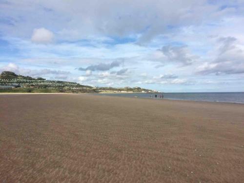 a sandy beach with people walking on the water at Family seaside home, easy access to Edinburgh in Kinghorn
