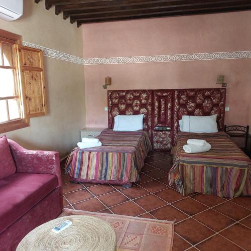 a living room with two beds and a couch at Chez Mamouchthka in Ourika