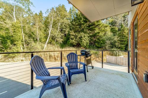 two blue chairs and a table on a porch at Serenity at Deerhaven #A & #B in Gold Beach