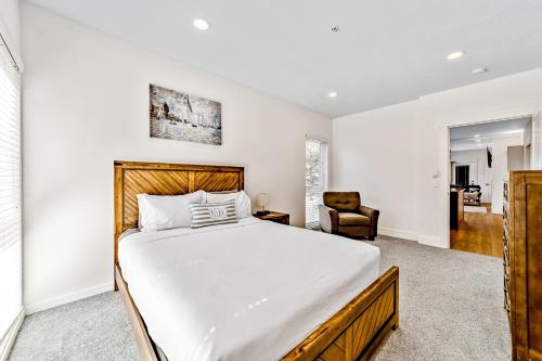 a bedroom with a large bed and a chair at Serenity at Deerhaven #A & #B in Gold Beach