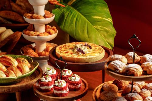 a table topped with different types of pastries and pies at Pousada Ecológica Akanã in Fernando de Noronha