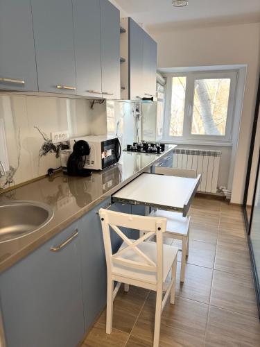 a kitchen with a sink and a table and a chair at Michael2 in Galaţi