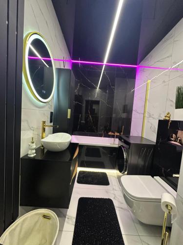 a bathroom with a sink and a tub and a toilet at Apartament Luxe z bezpłatnym parkingiem podziemnym in Koszalin