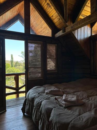 a large bed in a room with a large window at Glamping Luxury Estancia CerroBlanco in Tanti