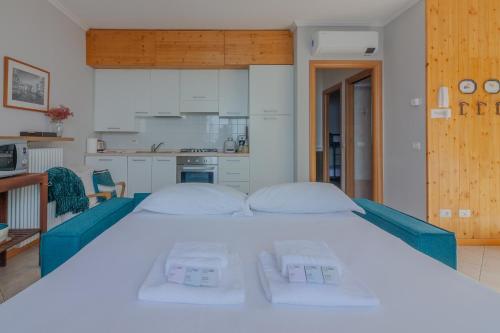 een groot wit bed in een kamer met een keuken bij Panorama del Lago in Perledo