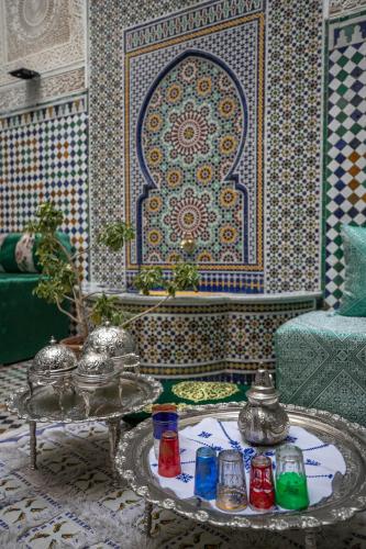 a living room with a table and a mosaic wall at Riad Yamna Fez in Fès