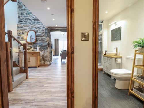a bathroom with a stone wall at Gaerau Bach in Llanbedr