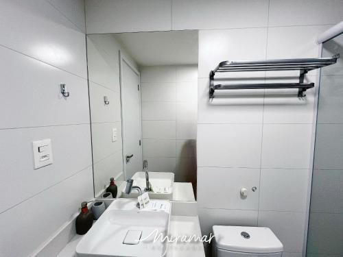 a bathroom with two sinks and a mirror at Vert House Jardim Oceania - Miramar Hospedagens in Tambaú