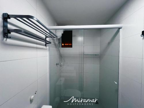 a shower with a glass door in a bathroom at Vert House Jardim Oceania - Miramar Hospedagens in Tambaú