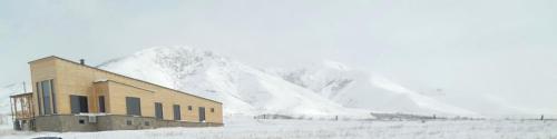 a building in front of a snow covered mountain at Denver Villa in Sagmosavan