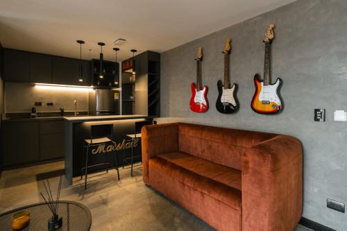 a living room with a couch and guitars on the wall at Indie Universe Creative Hotel in Medellín