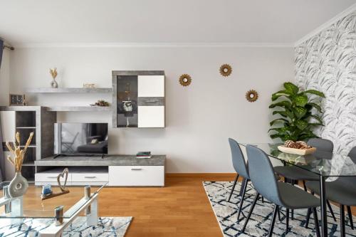 a living room with a table and chairs and a fireplace at Sunflower Living by Homie in Caniço