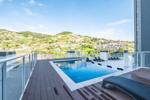 a balcony with a swimming pool on top of a building at Sunflower Living by Homie in Caniço