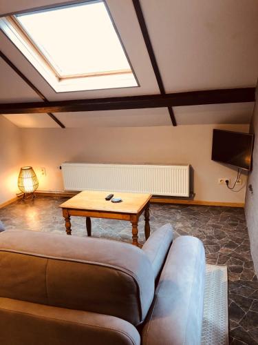 a living room with a couch and a table at Appart Hotel Au Pied de Vigne in Vresse-sur-Semois
