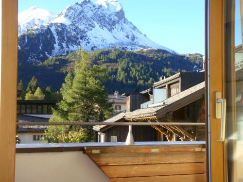 a view of a snow covered mountain from a window at Schweizerhaus Apartments in Maloja