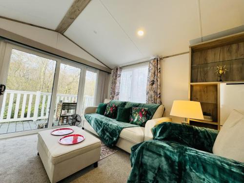 a living room with a couch and a table at Escape The City - Cozy Caravan Next To The Lake in Hastings
