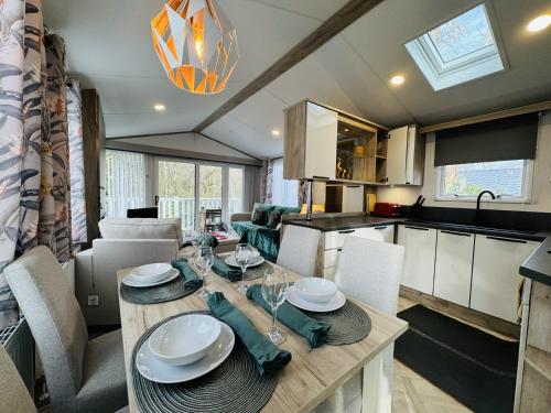 a kitchen and dining room with a table and chairs at Escape The City - Cozy Caravan Next To The Lake in Hastings