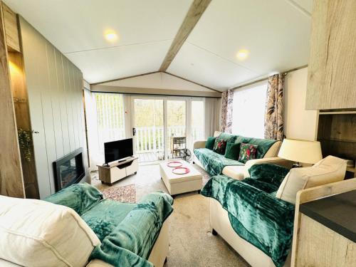 a living room with two couches and a tv at Escape The City - Cozy Caravan Next To The Lake in Hastings