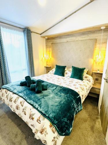 a bedroom with a large bed with green pillows at Escape The City - Cozy Caravan Next To The Lake in Hastings