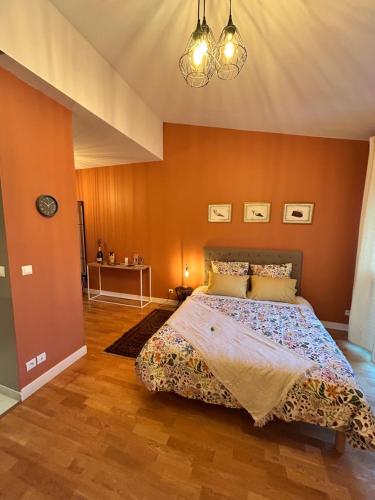 une chambre avec un grand lit aux murs orange dans l'établissement Le Flodoard Chic, à Épernay