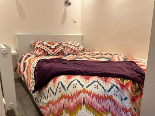 - un lit avec une couverture et des oreillers colorés dans l'établissement Appartement Le Suquet proche Croisette, à Cannes