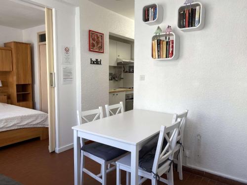- une table et des chaises blanches dans une chambre dans l'établissement Appartement T2 avec Wifi, Proche Thermes et Commodités, Parking, Classé 2 Étoiles - FR-1-553-235, à Balaruc-les-Bains