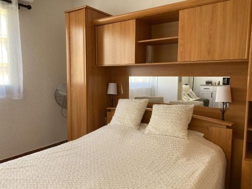 une chambre avec un lit avec une tête de lit en bois dans l'établissement Appartement T2 avec Wifi, Proche Thermes et Commodités, Parking, Classé 2 Étoiles - FR-1-553-235, à Balaruc-les-Bains