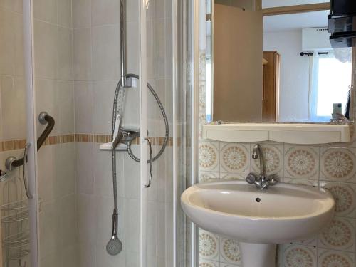 une salle de bain avec un lavabo et une douche avec un miroir dans l'établissement Appartement T2 avec Wifi, Proche Thermes et Commodités, Parking, Classé 2 Étoiles - FR-1-553-235, à Balaruc-les-Bains