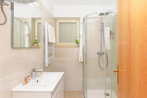 a bathroom with a sink and a shower at Seaview Apartment Bojan Rabac in Rabac