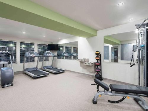 a gym with several treadmills and machines in a room at WoodSpring Suites Buford near Mall of Georgia-Lake Lanier in Buford