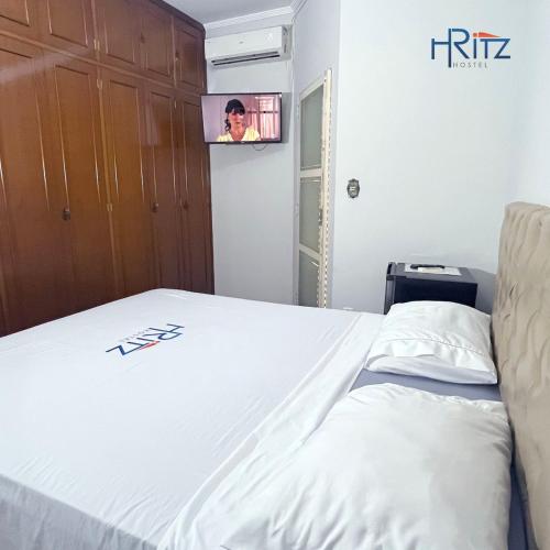 a bedroom with a bed with a tv on the wall at Ritz Hostel in Araçatuba