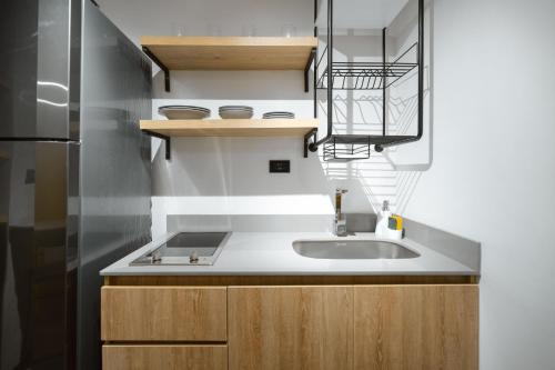 a small kitchen with a sink and a refrigerator at Indie Universe Creative Hotel in Medellín
