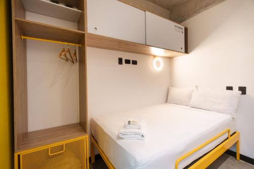 a small room with a bed and a cabinet at Indie Universe Creative Hotel in Medellín